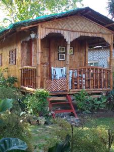a wooden house with a porch and a deck at Casa de Corazon in Kandabong +18 photos