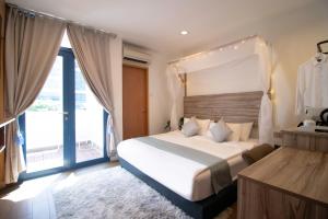 a bedroom with a large bed and a large window at Victoria Hotel a NuVe Group Collection in Singapore