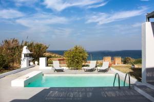 uma piscina com cadeiras e vista para o oceano em Superior Villa Lino em Skiros