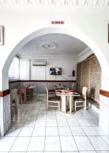 a restaurant with an archway and tables and chairs at Hill View Hotel McCarthy Hills in Bortianor
