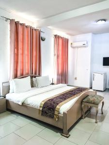 um quarto com uma cama grande e cortinas vermelhas em Hill View Hotel McCarthy Hills em Botianaw