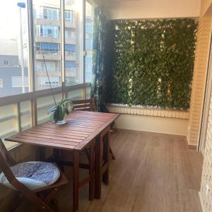 einen Tisch und Stühle in einem Zimmer mit grüner Wand in der Unterkunft Costa Dream Stay in Torrevieja