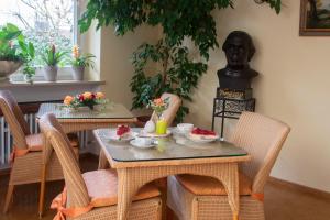 ein Esszimmer mit zwei Tischen und einer Statue in der Unterkunft Hotel Cebulj in Bad Wörishofen