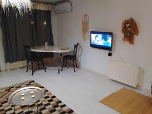 een woonkamer met een tafel en een tv aan de muur bij SidiBou House in Sidi Bou Saïd