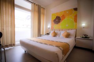 a bedroom with a large bed with a large window at Millennium Continental in Cochin