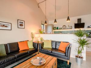 a living room with two leather couches and a coffee table at Yartleton Farm in Aston Ingham