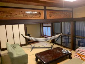 a living room with a hammock and a couch at 体験型民宿mishigo 