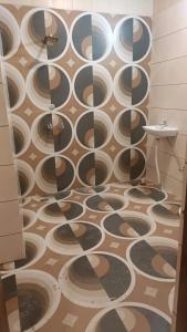 a bathroom with a shower with a patterned floor at Asha Guest House in Amritsar