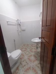 a bathroom with a toilet and a sink at ເຮືອນພັກບີວີ(BV Guesthouse) in Ban Thôngchai-Tai