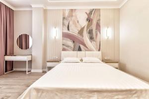 um quarto com uma grande cama branca e um quadro em Двухкомнатные аппартаменты Вдохновение в центре столицы em Astana