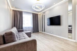 uma sala de estar com um sofá e uma televisão de ecrã plano em Двухкомнатные аппартаменты Вдохновение в центре столицы em Astana