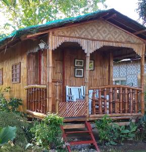 Casa de madera con porche y terraza en Casa de Corazon, en Kandabong