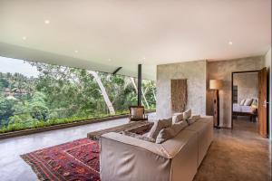 乌布Hidden Gem Suites Ubud的带沙发和大窗户的客厅