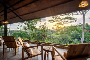 乌布Hidden Gem Suites Ubud的一间有椅子并能欣赏森林景色的房间