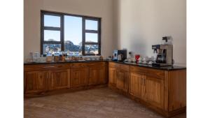 una cocina con armarios de madera y una ventana en Sandune Game Lodge en Gobabis