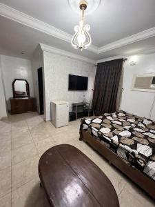 アブジャにあるGreat 3 bedroom Apartment in the city centerのベッドルーム(ベッド1台、テレビ、テーブル付)