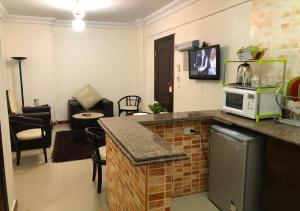 a living room with a kitchen with a microwave at Bonne Vie Hotel in 6th Of October