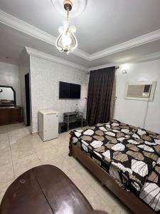 アブジャにあるGreat 3 bedroom Apartment in the city centerのベッドルーム(ベッド1台、テレビ、シャンデリア付)