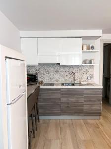 uma cozinha com armários brancos e um frigorífico branco em Catanese Proverb's House - Via Napoli em Catânia