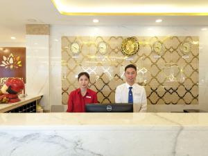 a man and a woman standing in front of a computer at Đông Kinh Hotel in Ho Chi Minh City