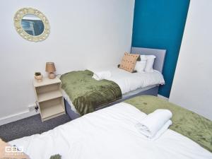 two beds in a room with a mirror at Supersized 5bed house/Birmingham/Monthly discounts in Birmingham