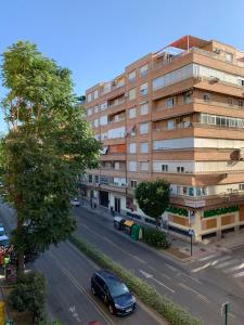un coche conduciendo por una calle al lado de un edificio en Apartamento nuevo, 3 dormitorios con terraza, en Granada