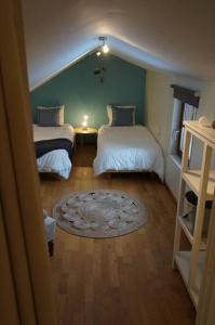 a small room with two beds and a rug at Le Walkoti - cosy cottage with 2 bedrooms in Waimes