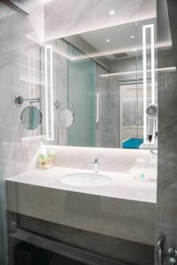 y baño con lavabo blanco y espejo. en Crystal Inn, en Batu Pahat