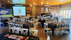 a dining room with tables and chairs and a projection screen at Mukumbura Swartwater 