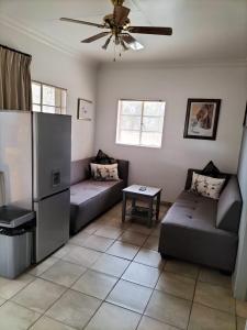 a living room with a couch and a refrigerator at Mukumbura Swartwater 