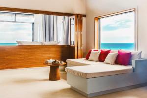 a room with a couch and a window with the ocean at สิชลเตโซโร in Ban Thong Yang