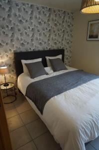 a bedroom with a large bed with white sheets and pillows at Le Walkoti - cosy cottage with 2 bedrooms in Waimes