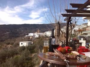 a table with a glass of wine and food on it at Hotel Rural Real de Laroles Nevada bike and treeking in Laroles