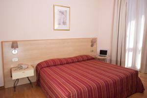 A bed or beds in a room at Hotel Ziò Imola