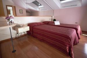 A bed or beds in a room at Hotel Ziò Imola
