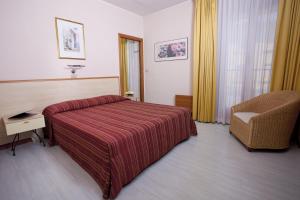 A bed or beds in a room at Hotel Ziò Imola
