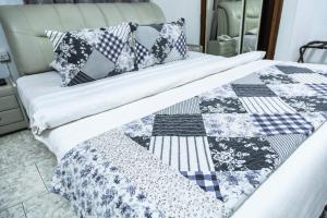 łóżko z kołdrą i poduszkami w obiekcie Hill View Hotel West Airport w Akrze