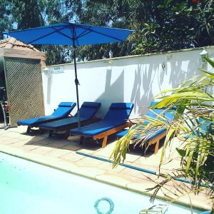 a group of chairs and an umbrella next to a pool at Havre De Paix in Somone