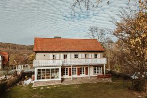 duży biały dom z pomarańczowym dachem w obiekcie Waldchalet Am Steinberg w mieście Wernigerode