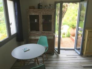 comedor con mesa, sillas y ventana en Magnifique studio dans maisonnette, en Tourrettes-sur-Loup