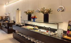 a buffet line with food on display in a restaurant at Hotel Katharinenhof COMFORT in Dornbirn