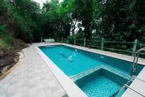 a swimming pool in a yard with a bench at Tea Valley Resort, Munnar in Munnar