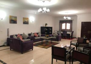 ein Wohnzimmer mit Sofas, Stühlen und einem Tisch in der Unterkunft Bonne Vie Hotel in Madinat as-Sadis min Uktubar