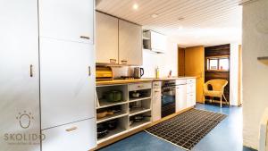 een keuken met witte kasten en een koelkast bij Heimeliges Walliserhaus in Fiesch