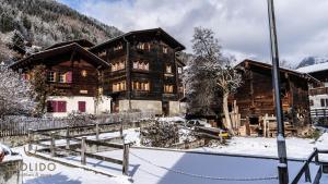 a large wooden house with snow on the ground at Heimeliges Walliserhaus in Fiesch
