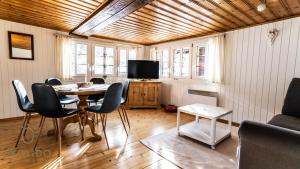 een woonkamer met een tafel en stoelen en een televisie bij Heimeliges Walliserhaus in Fiesch