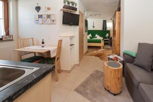 eine Küche und ein Wohnzimmer mit einem Waschbecken und einem Tisch in der Unterkunft Alpineas in Leutasch