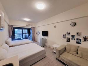 1 dormitorio con cama, sofá y TV en 暖暖窩溫泉湯旅 en Yü-shih-ts'un