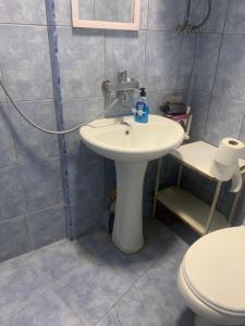 a bathroom with a white sink and a toilet at Leila Apartment in Tbilisi City +45 photos