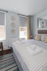 een slaapkamer met een groot bed en 2 handdoeken bij The Eagles in Ramsgate
